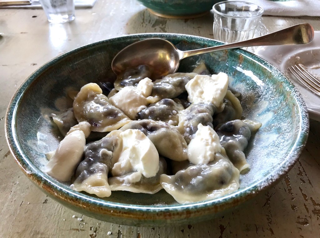 Pierogi dumplings with bilberries and cream