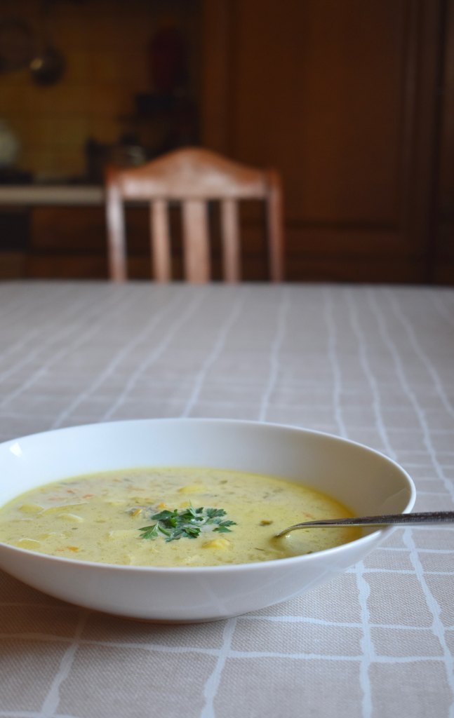 A plate of green soup on a kitchen table 