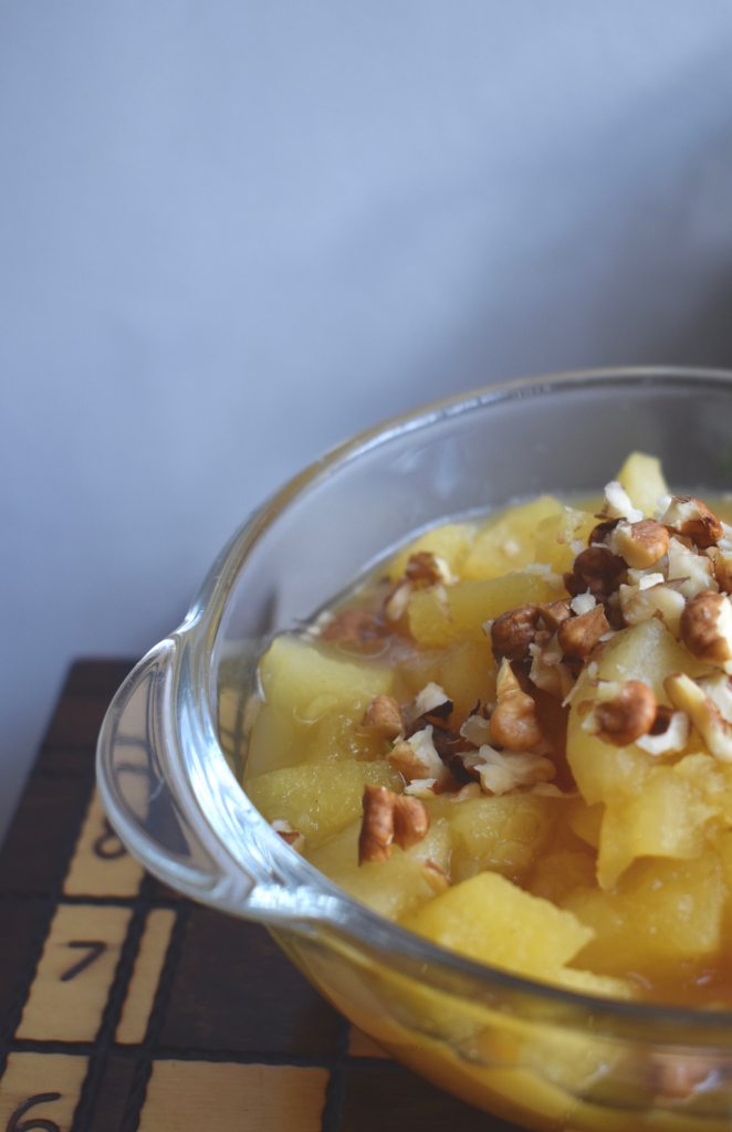 Apple compote with chopped walnuts in a bowl on a chessboard