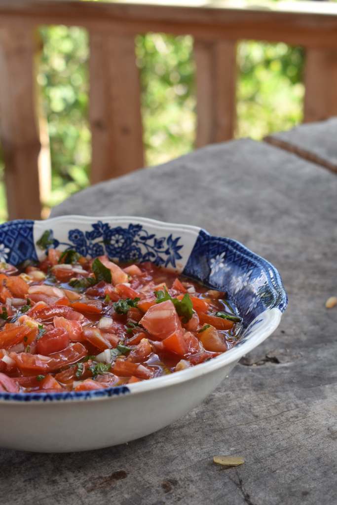 chopped tomato and herb salad in a blue and white bowl