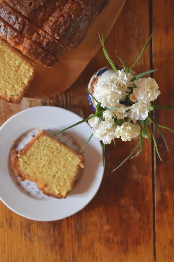 slice of loaf cake on a white plate with white flowers 